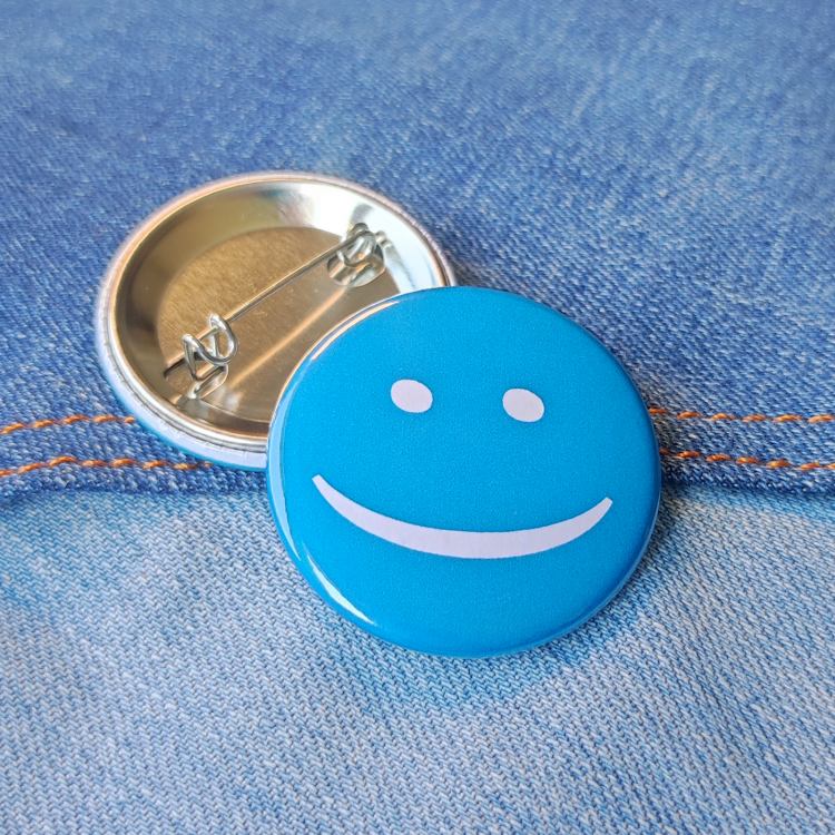 Ansteckbutton Smiley Blau auf Jeans mit Rückseite